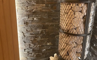 Отделка стены за печкой в парной натуральным камнем сланцем Rustic Rockface